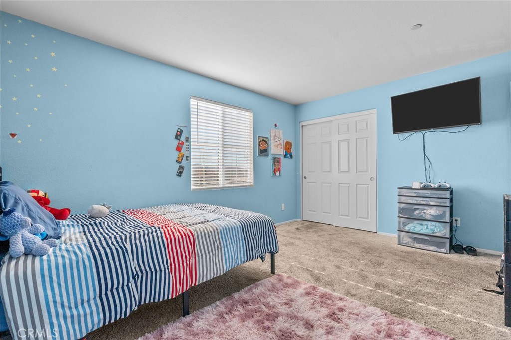 6949 Beale Road Palmdale, CA 93552 - Photo 17 of 32 a bedroom with a bed and a flat screen tv