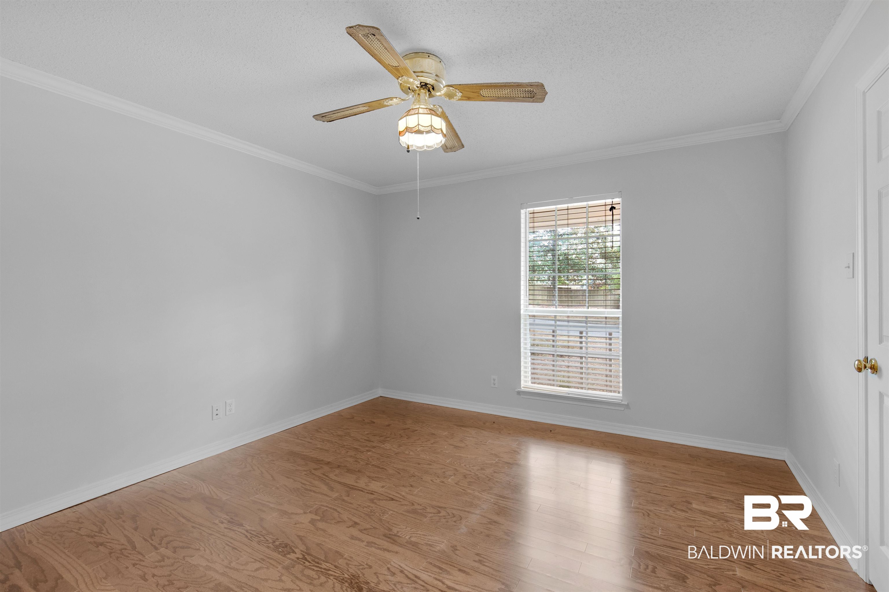 7225 Smithfield Road East Mobile, AL 36695 - Photo 12 of 27 Unfurnished room with ornamental molding, baseboards, ceiling fan, and wood finished floors