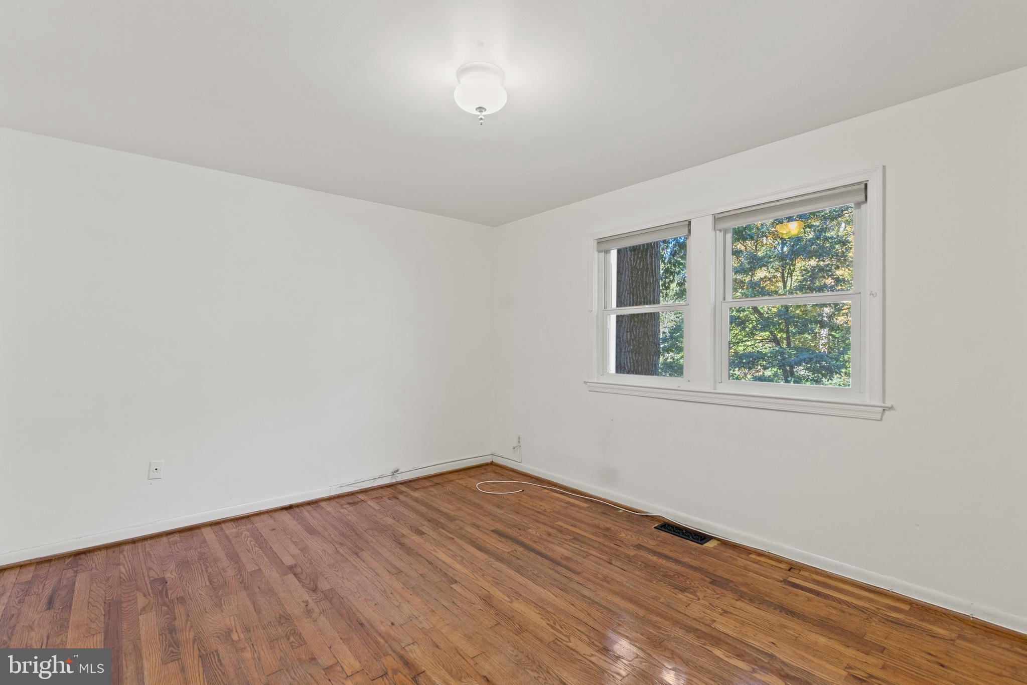 8547 Bradford Road, Unit 92 Silver Spring, MD 20901 - Photo 12 of 24 wooden floor in an empty room with a window