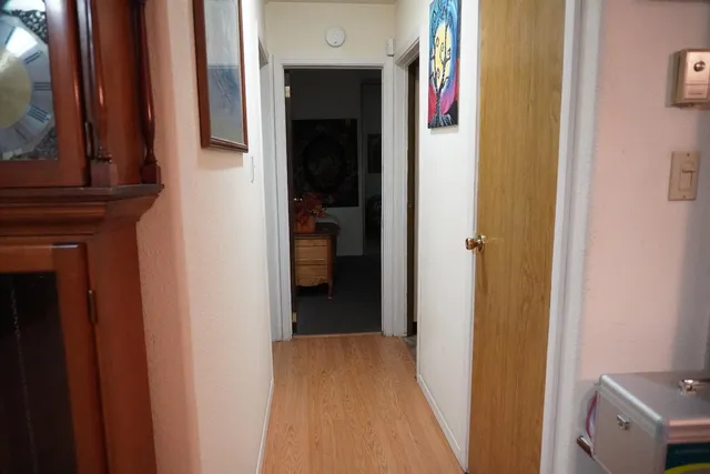 a view of a hallway with wooden floor and entryway