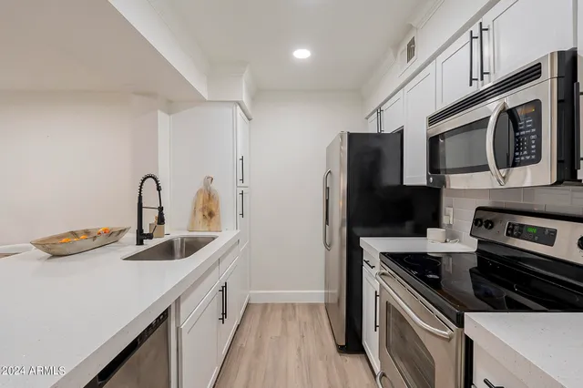 a kitchen that has a sink and a stove top oven
