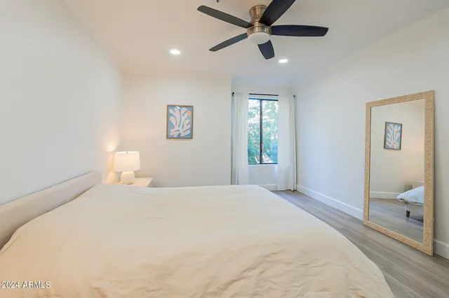 a bedroom with a large bed and a chandelier