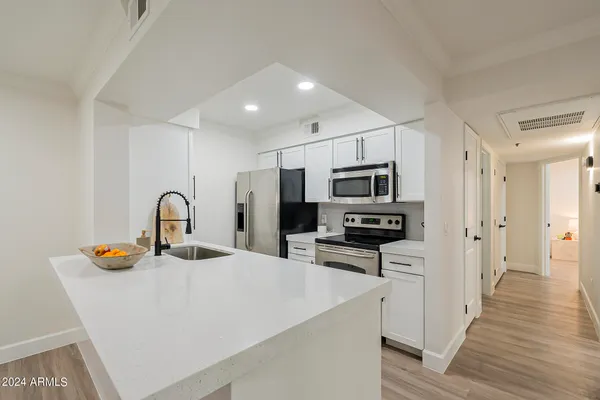 a kitchen with stainless steel appliances a refrigerator a stove a microwave and cabinets