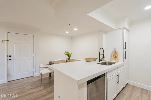 a kitchen with a sink cabinets and wooden floor