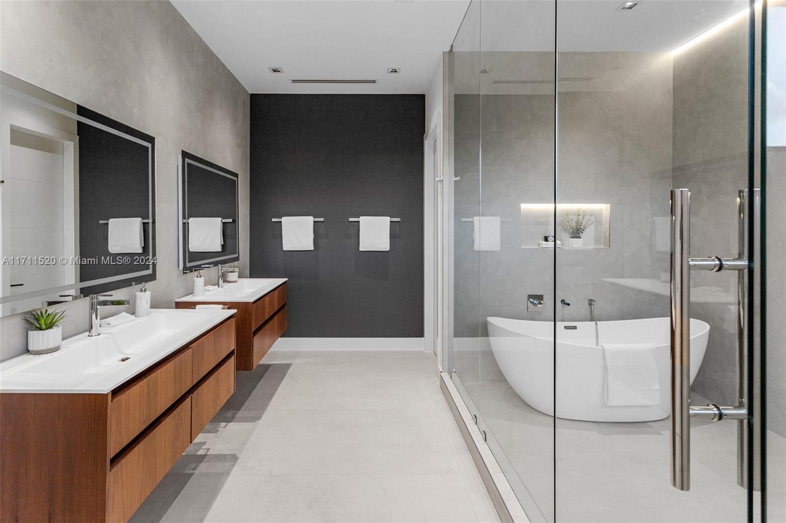7635 Southwest 72nd Avenue Miami, FL 33143 - Photo 48 of 75 a bathroom with a double vanity sink a mirror and a bathtub