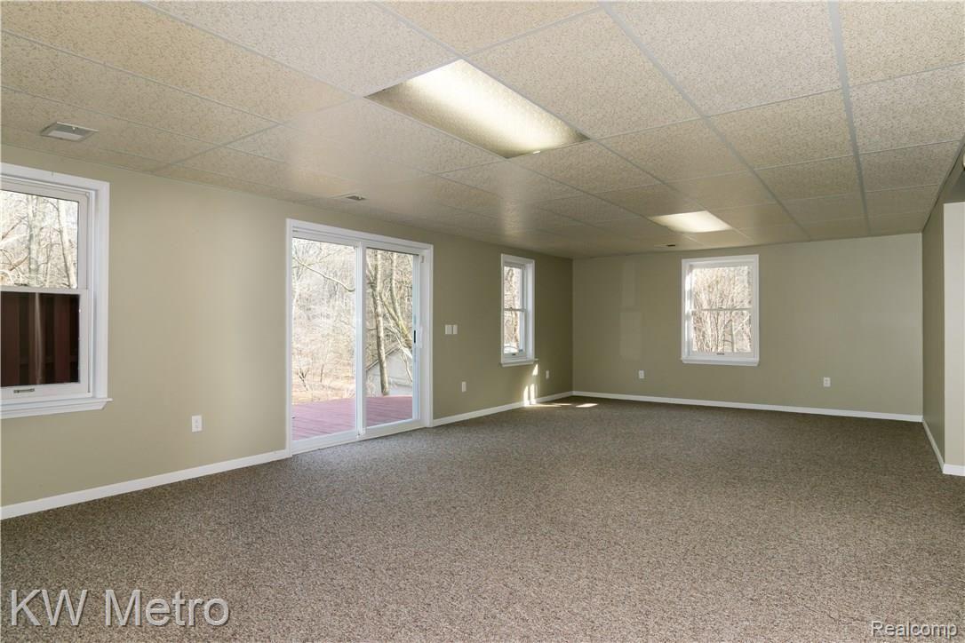 2211 West Wardlow Road Highland, MI 48357 - Photo 35 of 53 Full length finished basement w/ walkout leading to yard & deck.