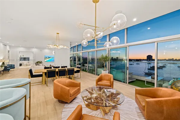 a living room with furniture kitchen view and a large window