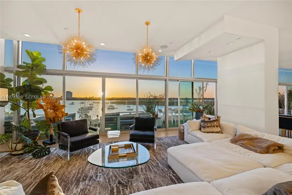 a living room with furniture chandelier and a large window