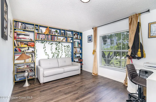 a living room with furniture a rug and a book shelf