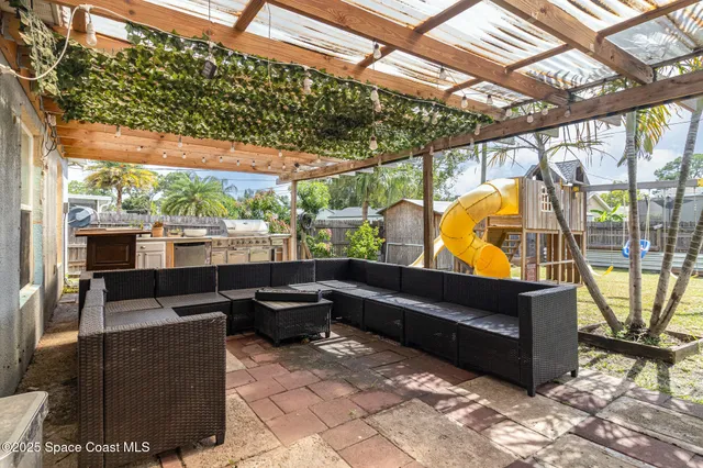 a backyard of a house with sofas table and chairs