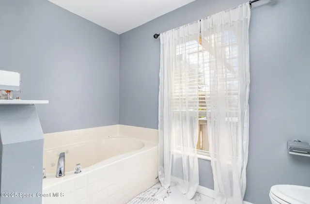 a white bath tub sitting next to a white toilet