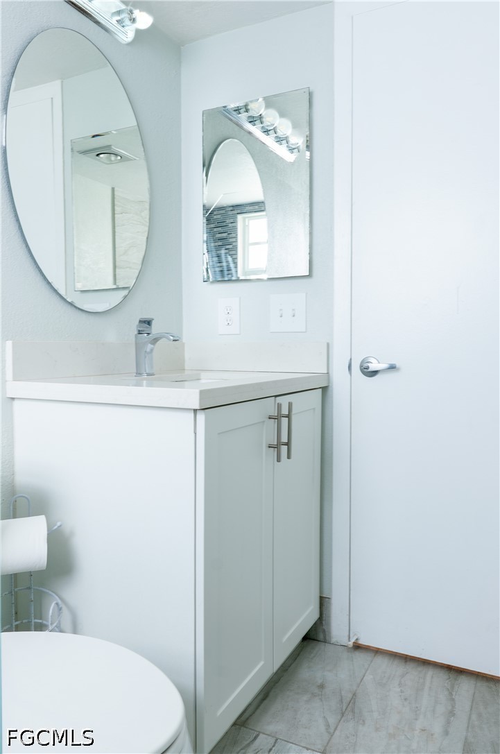 592 Fanshaw Way, Unit O Boca Raton, FL 33434 - Photo 11 of 25 a bathroom with a toilet a sink and a mirror
