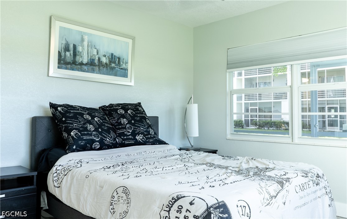 592 Fanshaw Way, Unit O Boca Raton, FL 33434 - Photo 12 of 25 a bed sitting in a bedroom next to a window with a large bed