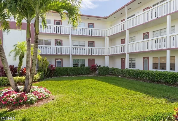 a front view of a residential apartment building with a yard