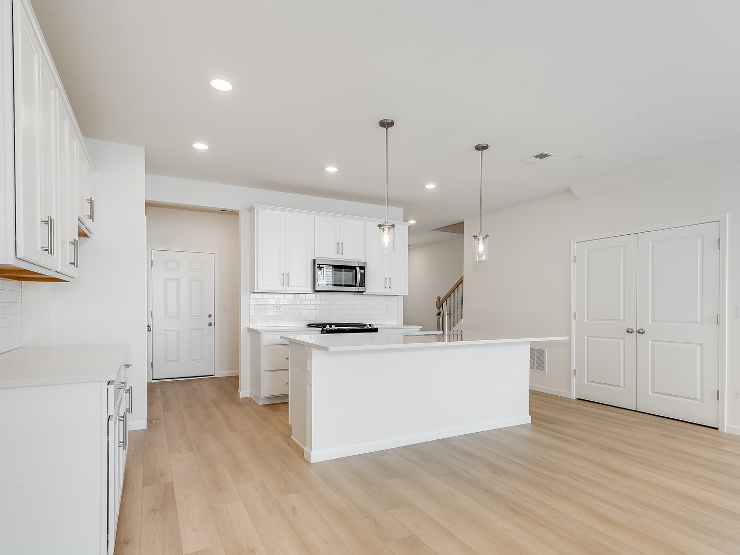 660 Switchgrass Way, Unit 58002 Bolingbrook, IL 60490 - Photo 6 of 24 a large white kitchen with a stove a sink dishwasher and a refrigerator with wooden floor