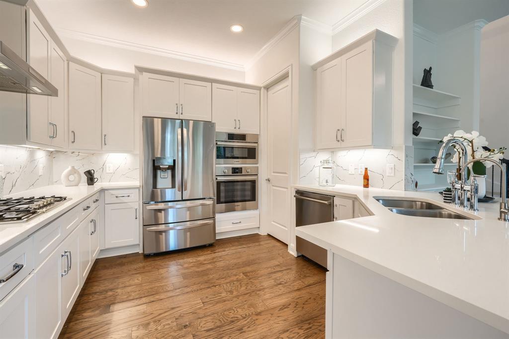 3101 Raphael Court McKinney, TX 75070 - Photo 2 of 40 a kitchen with white cabinets and stainless steel appliances