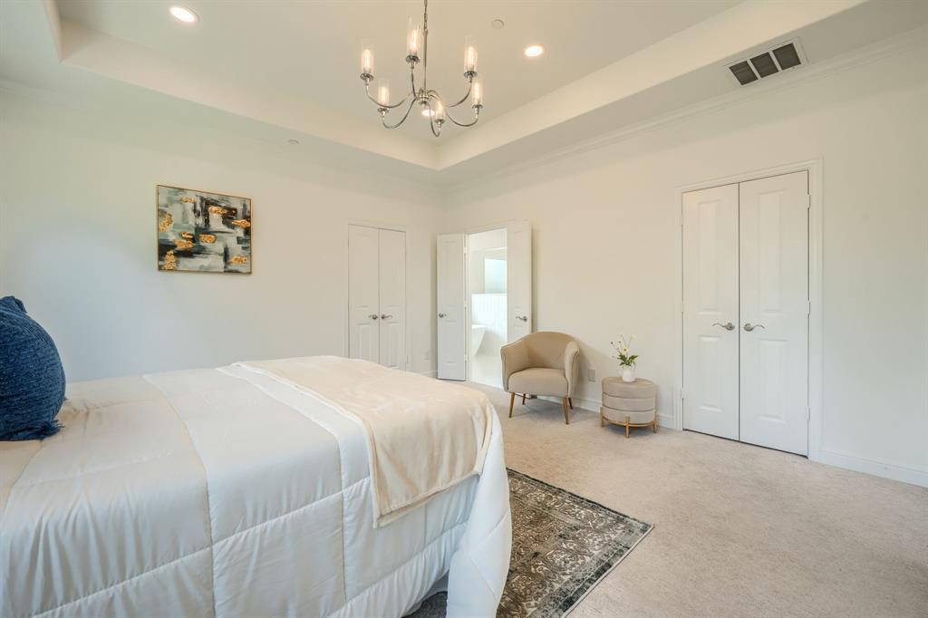 3101 Raphael Court McKinney, TX 75070 - Photo 29 of 40 a bedroom with a large bed and a chandelier