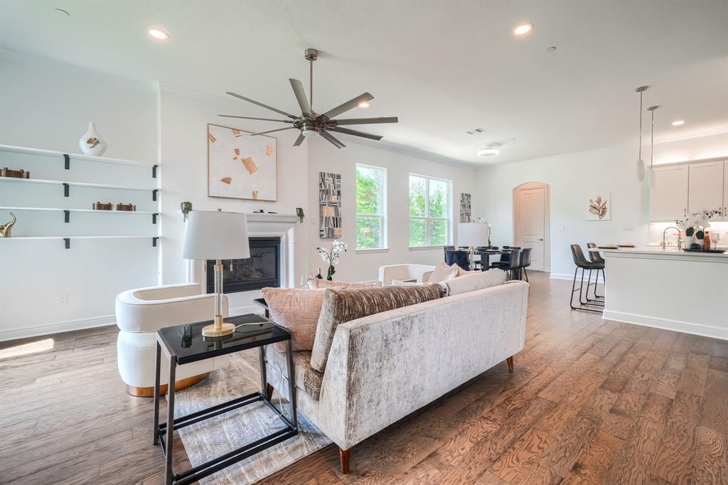 3101 Raphael Court McKinney, TX 75070 - Photo 3 of 40 a living room with furniture a fireplace and a ceiling fan