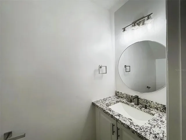 a bathroom with a sink and mirror with toilet