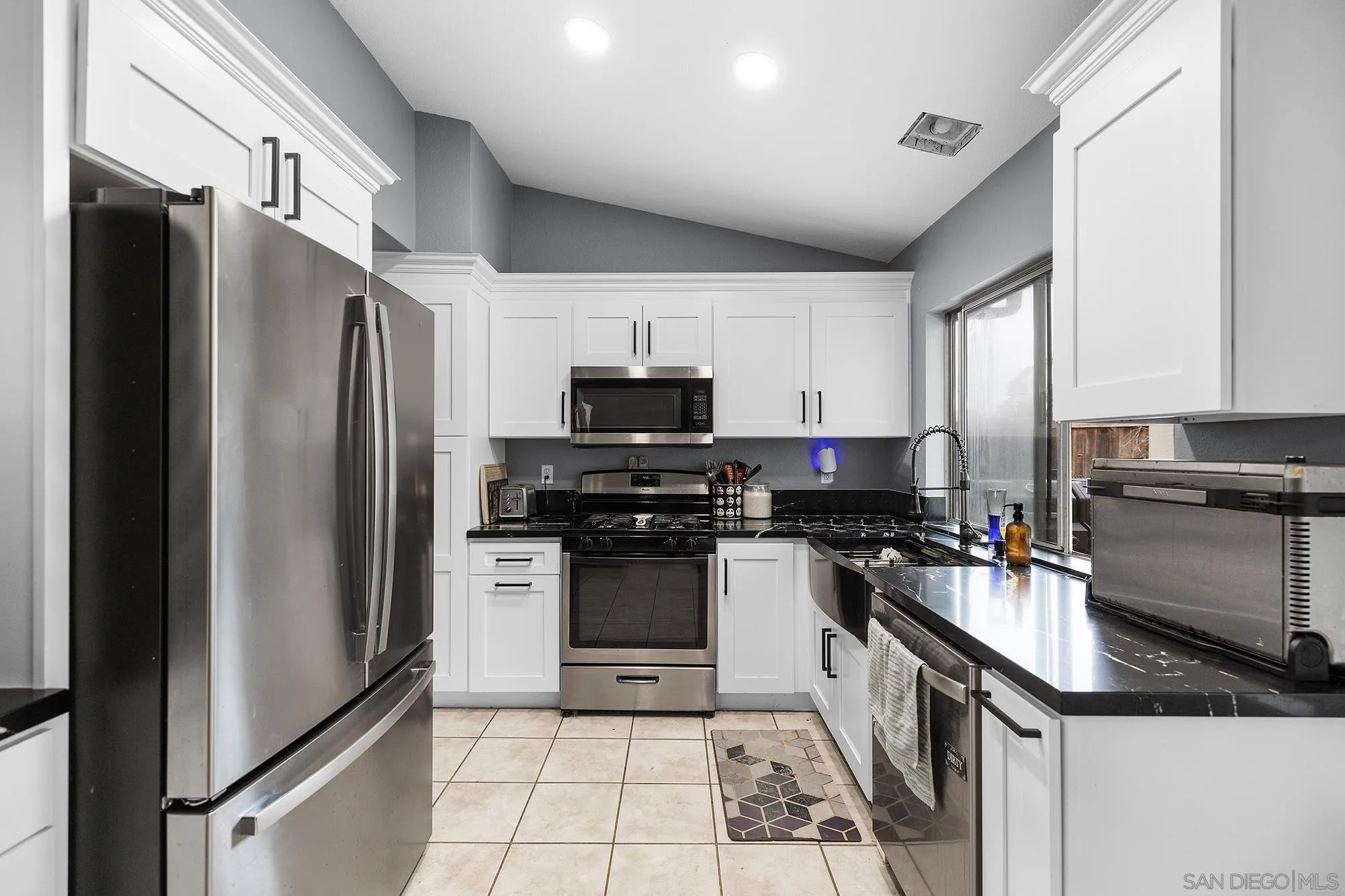 31297 Huron Street Temecula, CA 92592 - Photo 9 of 42 a kitchen with a refrigerator a sink and a stove top oven