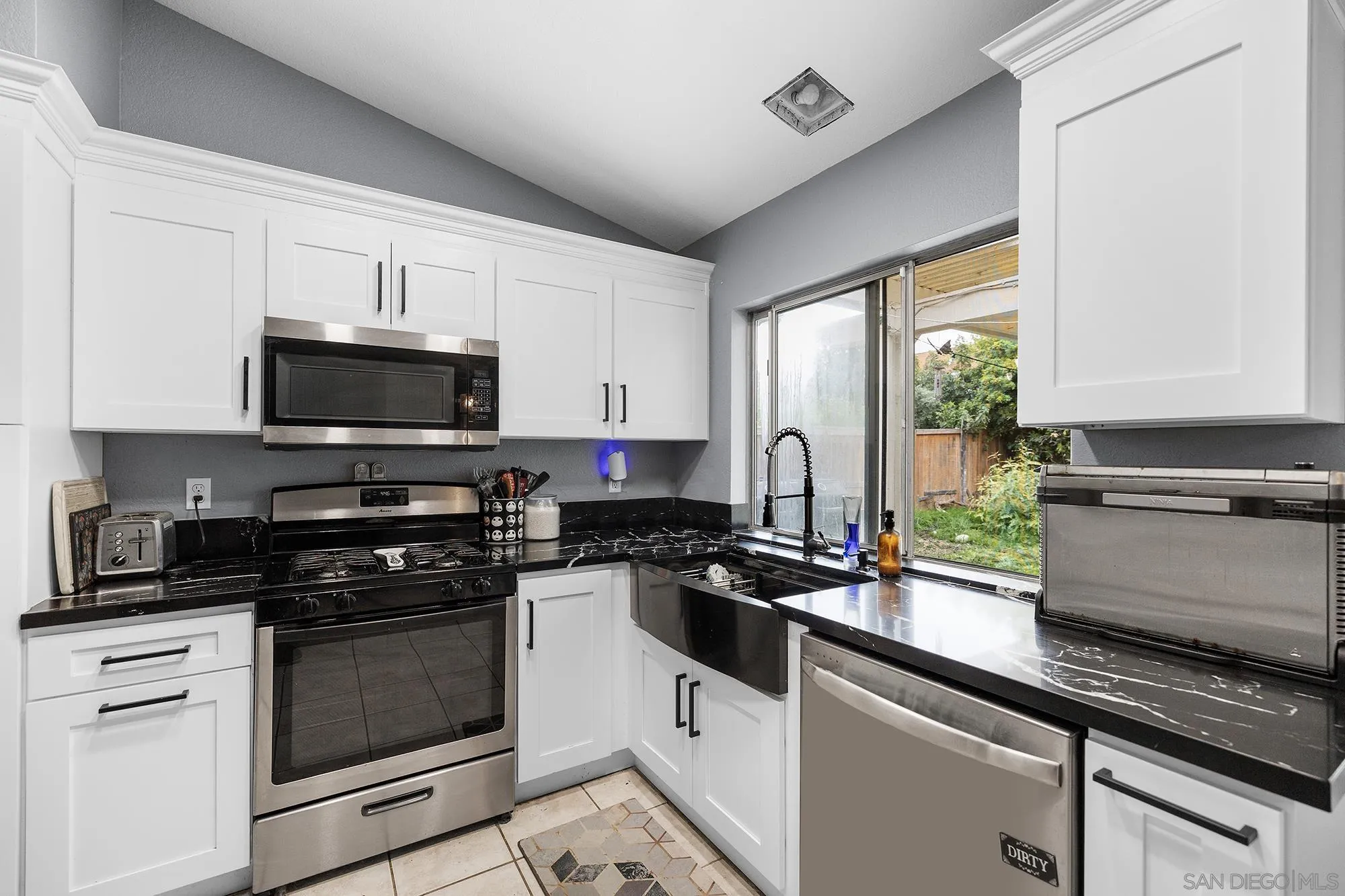 31297 Huron Street Temecula, CA 92592 - Photo 10 of 42 a kitchen with granite countertop white cabinets appliances and a window