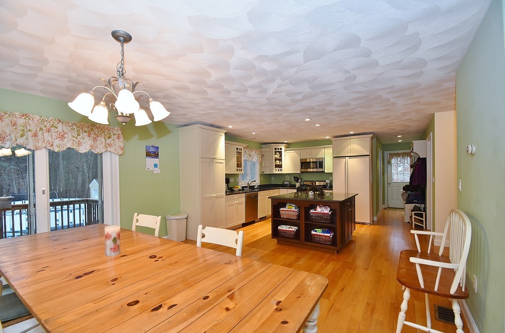 48 Partridge Road Billerica, MA 01821 - Photo 5 of 19 a dining room with wooden floor a chandelier a wooden table and chairs