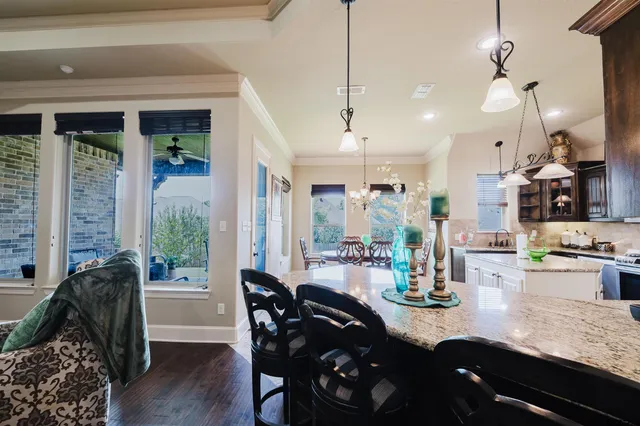 a view of a dining room and livingroom with furniture wooden floor a chandelier