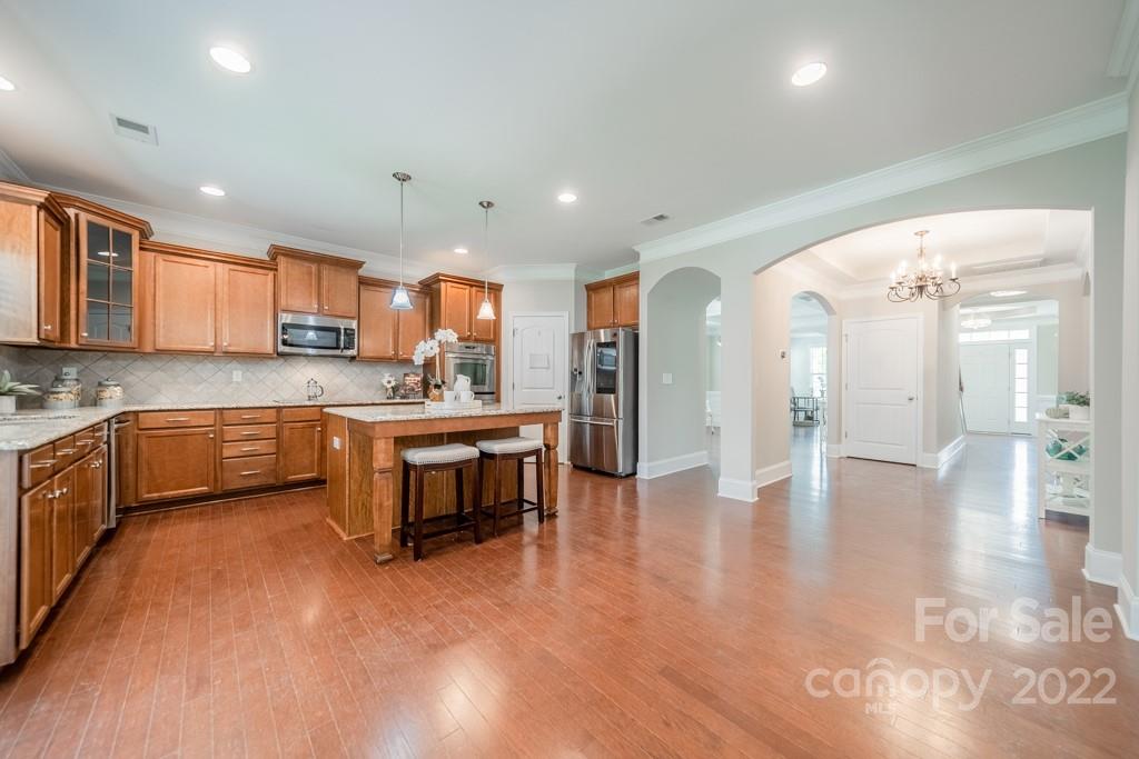 79109 Ridgehaven Road Lancaster, SC 29720 - Photo 10 of 48 a kitchen with stainless steel appliances granite countertop a refrigerator a sink a stove and a wooden cabinets with wooden floor