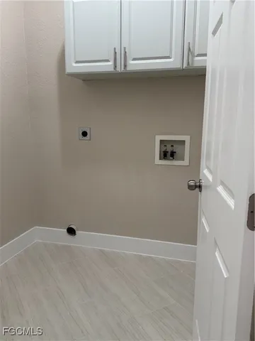 an empty room with wooden floor chandelier fan and windows