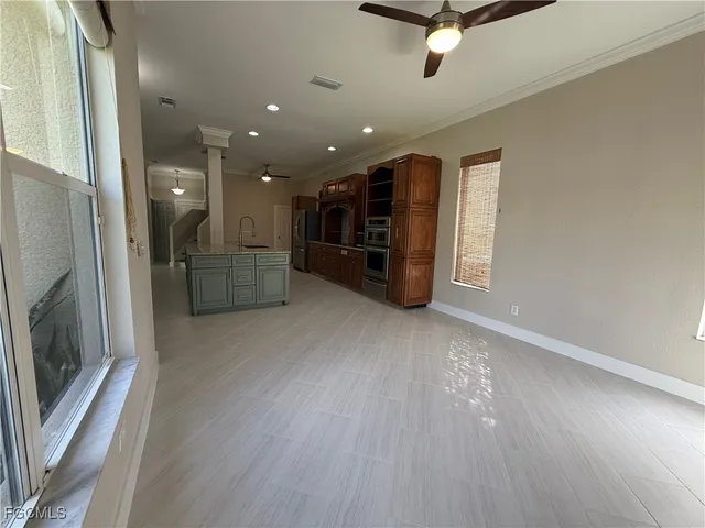 a large kitchen with a large counter top and stainless steel appliances