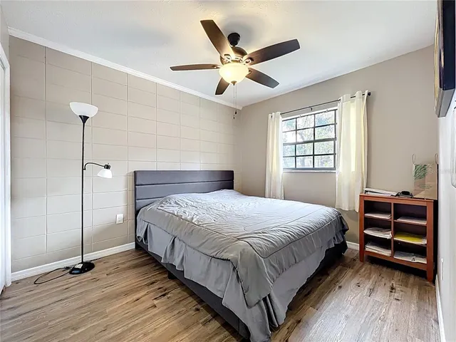 a bedroom with a bed and a ceiling fan