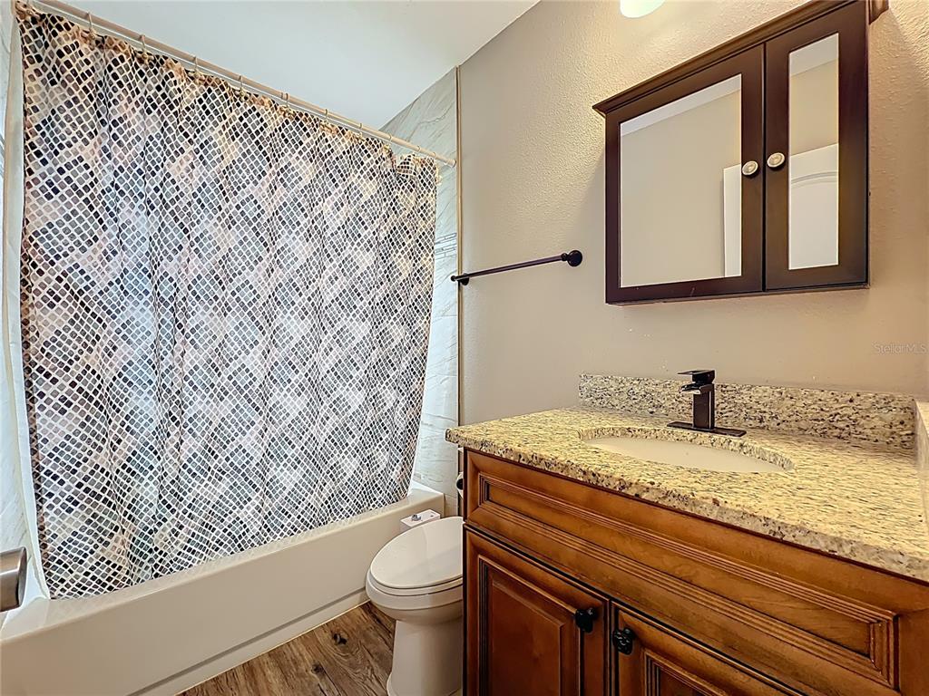 1304 Alfred Street, Unit A Brandon, FL 33510 - Photo 22 of 25 a bathroom with a granite countertop sink toilet and mirror