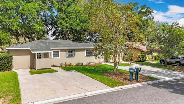 a front view of a house with a garden and trees