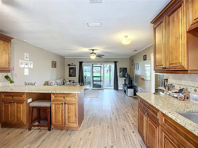 a large kitchen with stainless steel appliances granite countertop a lot of counter space and wooden floors