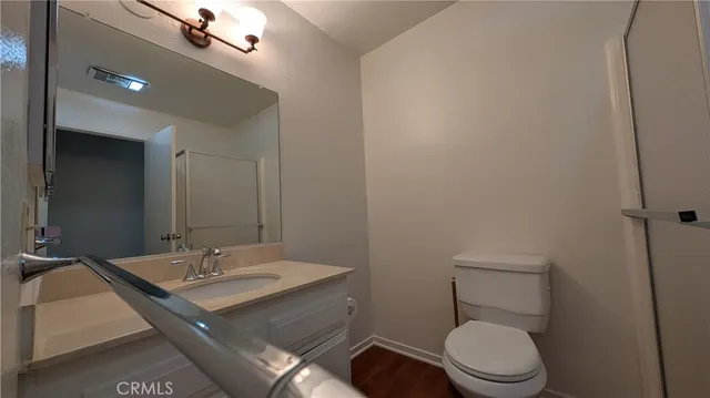 a bathroom with a sink a toilet a mirror and vanity