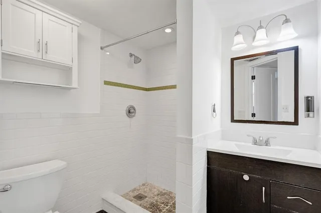 a bathroom with a sink a toilet and shower