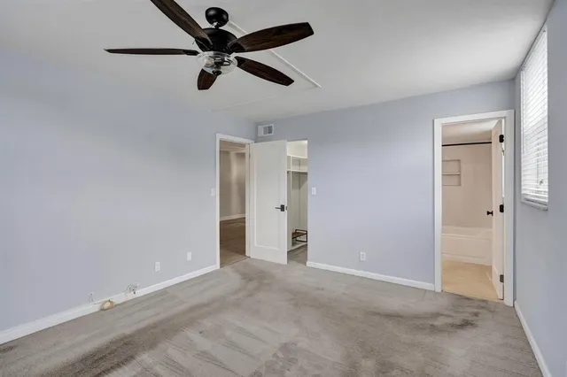 a view of an empty room and a ceiling fan