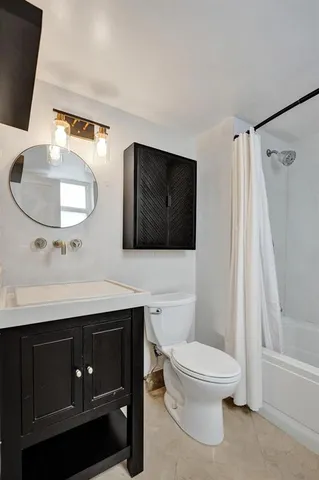 a bathroom with a toilet a sink and mirror