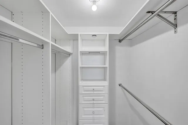a view of walk in closet with empty racks