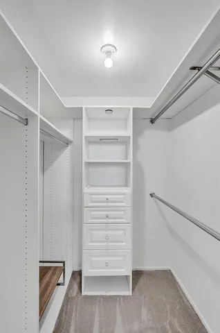 a view of walk in closet with empty racks