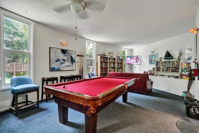 a room with furniture pool table and window