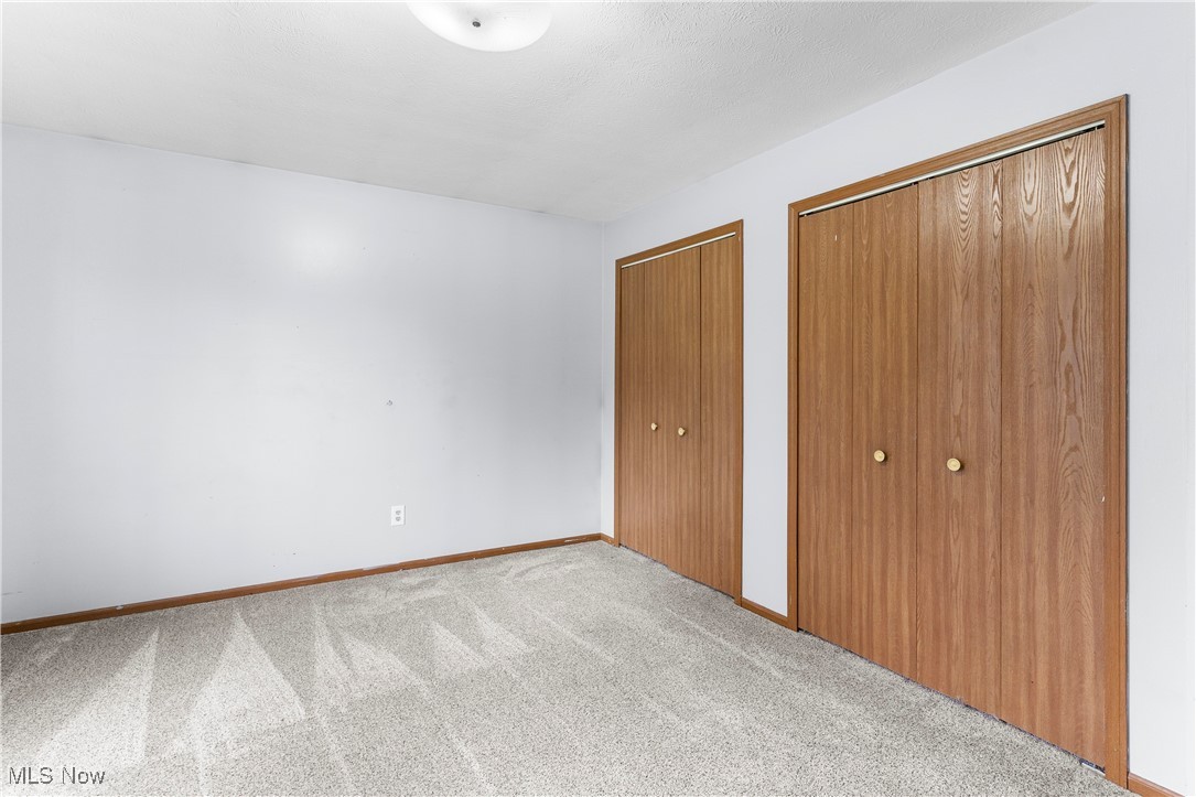 4075 Kirk Road Austintown, OH 44511 - Photo 17 of 40 Unfurnished bedroom featuring carpet flooring, baseboards, and two closets