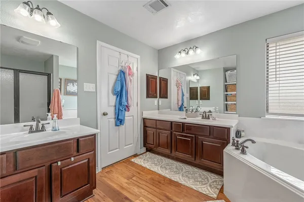 a spacious bathroom with a tub sink and mirror