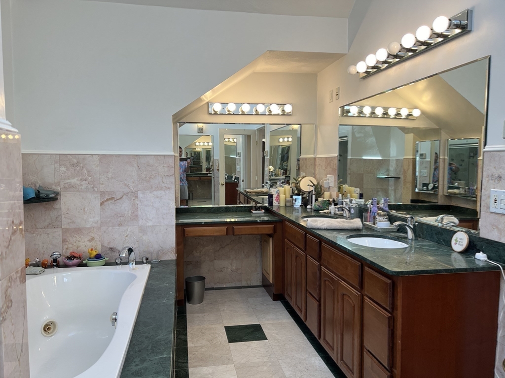 11 Garrison Road, Unit 1 Arlington, MA 02474 - Photo 26 of 42 a bathroom with a granite countertop sink a large mirror and a bathtub