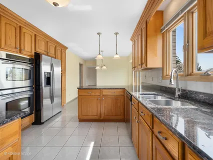 a kitchen with stainless steel appliances granite countertop a sink and cabinets