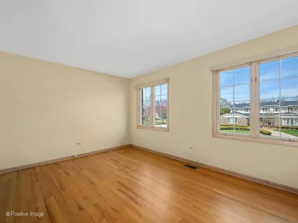 a bathroom with a granite countertop toilet a sink a mirror and a window