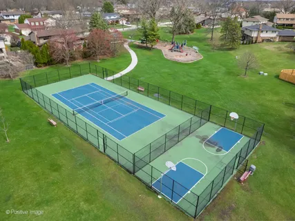 an aerial view of residential houses with outdoor space and trees