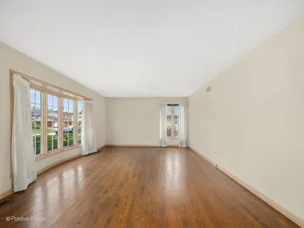 a dining room with furniture a window and wooden floor