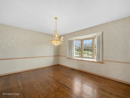 a dining room with furniture a chandelier and kitchen view