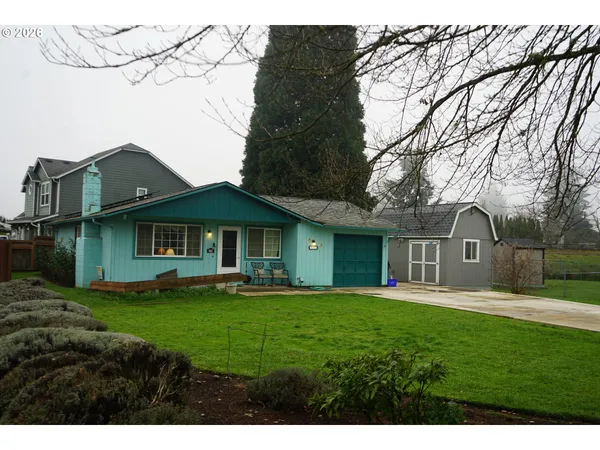 a front view of a house with a yard and trees